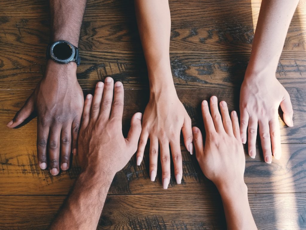 diverse hands next to each other on the table
