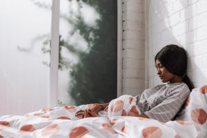 Sad teenage girl lying on bed. Photo by Anete Lusina on Pexels.