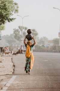 A woman carries water home on her head - Photo by Ibrahim Rifath on Unsplash