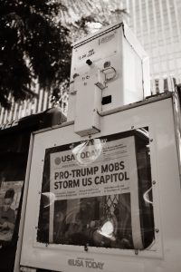 Greyscale photo of USA Today newspaper stand reading "Pro-Trump Mobs Storm US Capitol"